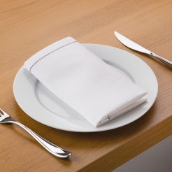 A white linen table napkin on top of a white plate