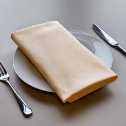 A ivory linen table napkin on top of a white plate