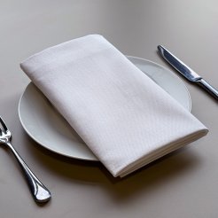 A white linen table napkin on top of a white plate