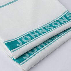 A kitchen cloth neatly stacked on top of another cloth, both featuring a teal stripe